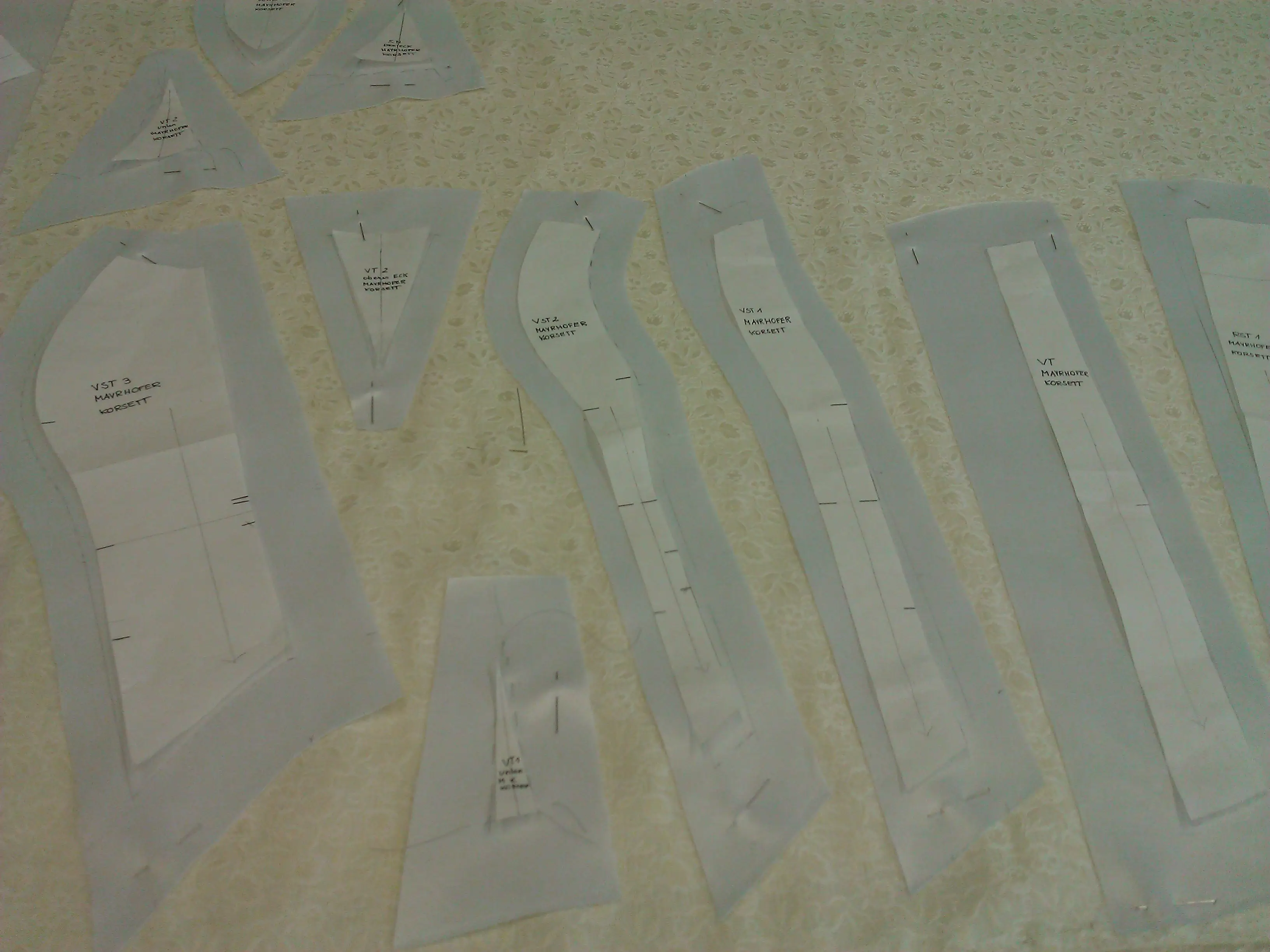 Paper pattern pieces for the stays laid out on fabric
