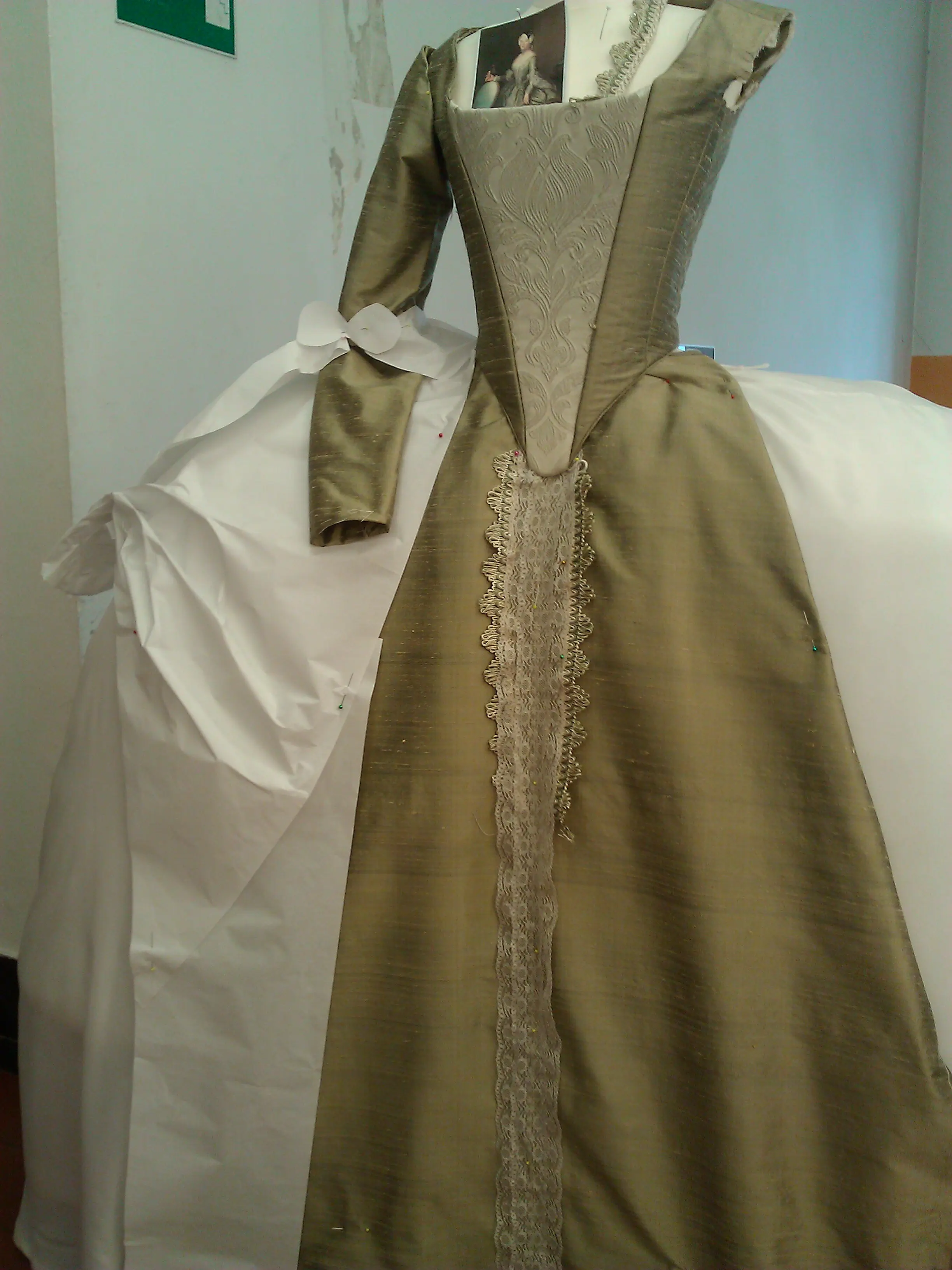 Full view of the robe’s back spread over the panier on the form