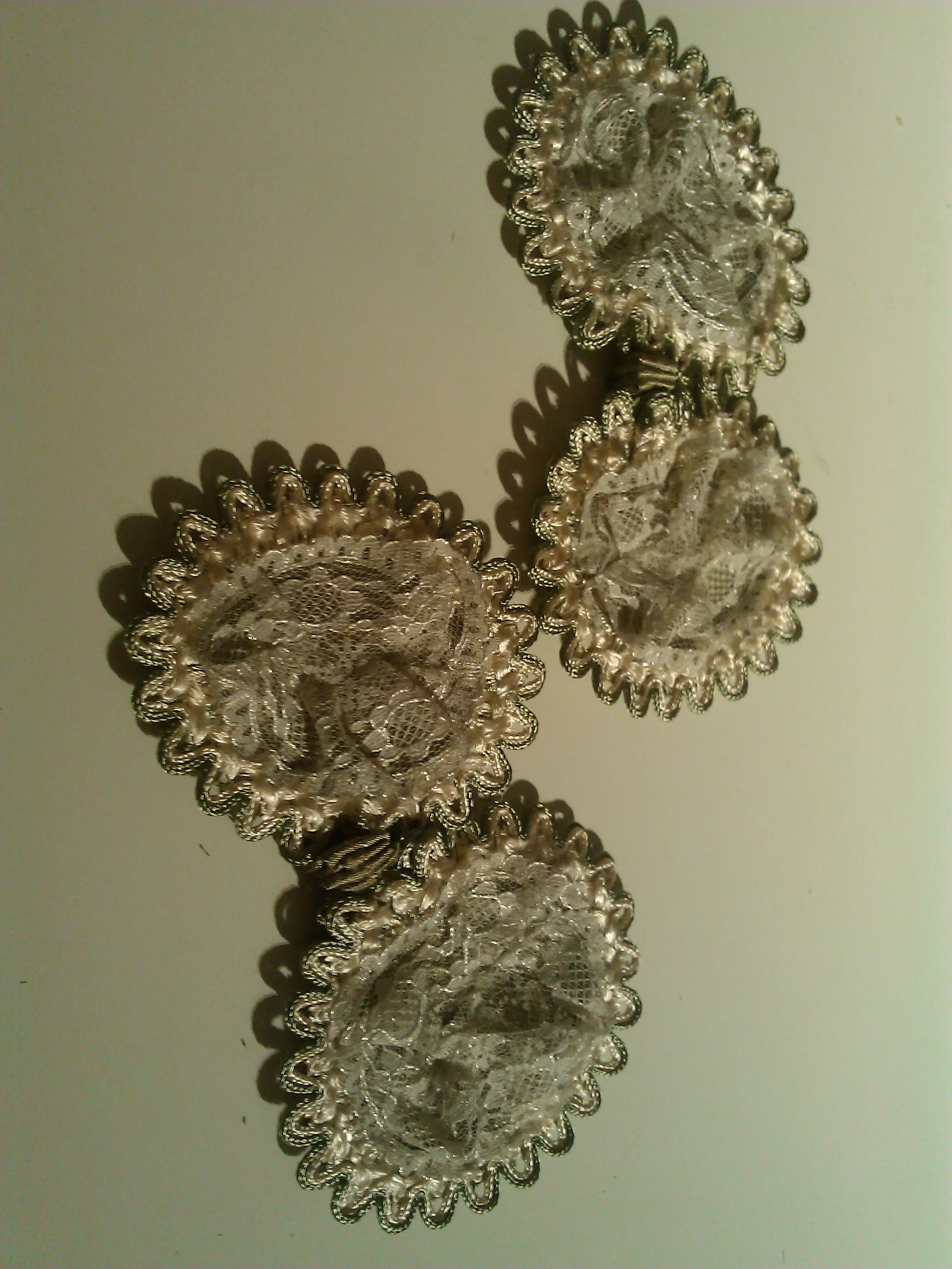 Several hand-made silver passementerie rosettes for the hat